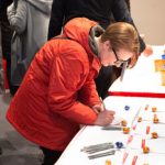 Photo: Employee signing a thank you card at table